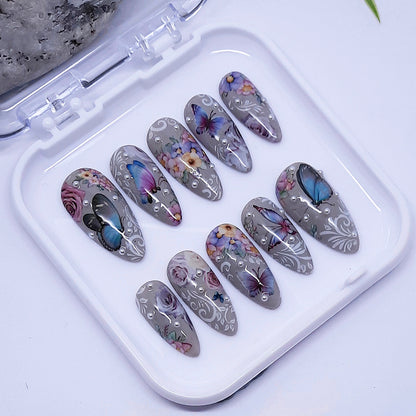 Set of decorative nail art designs in a white case on a light background