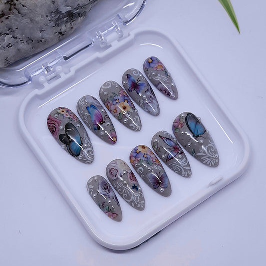 beautiful grey hand made press on nails with flowers, butterflies, white vines and pearls