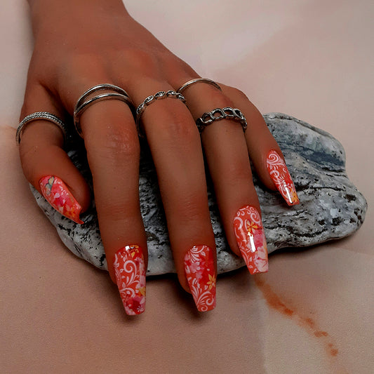 beautiful hand made press on nails in a coral gel polish, with flowers and white vines