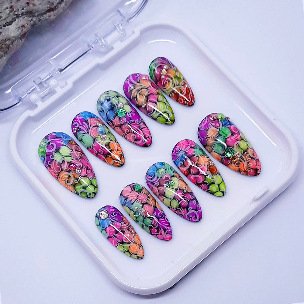 A set of colourful press on nails decorated with some 3d nail art.