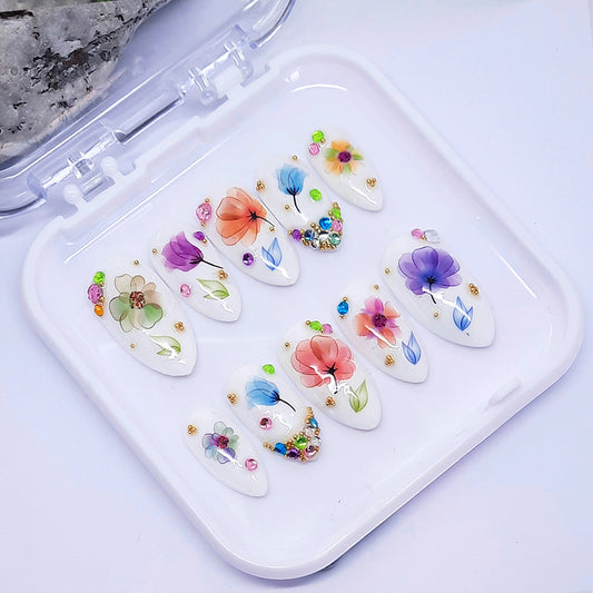 Set of nail art decorations with floral designs on a white tray.