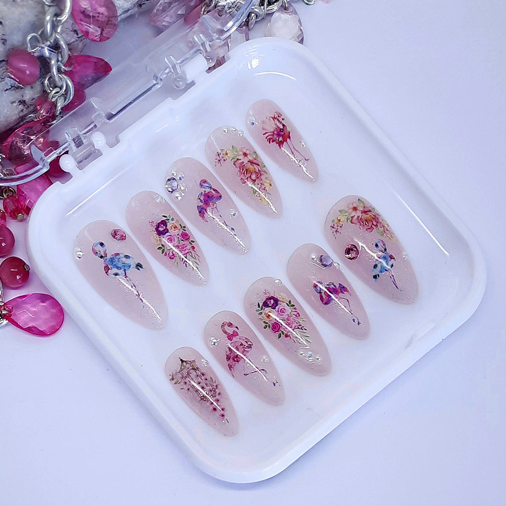 sparkly press on nails with a design of flamingosand flowers, with some pearls and gems