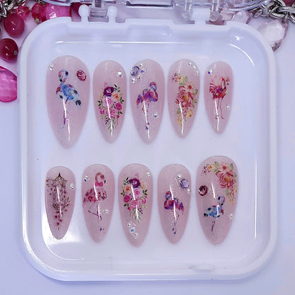 sparkly press on nails with a design of flamingosand flowers, with some pearls and gems