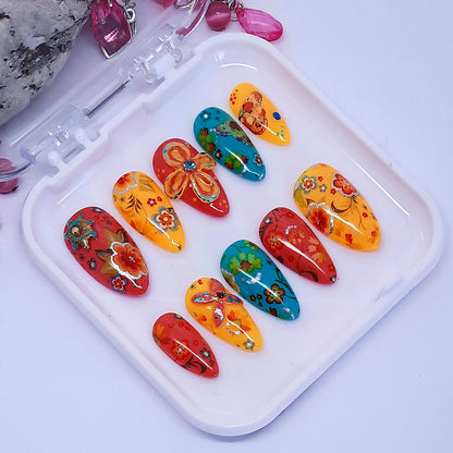 very colourful hand made press onnails with a floral design and 3d nail art