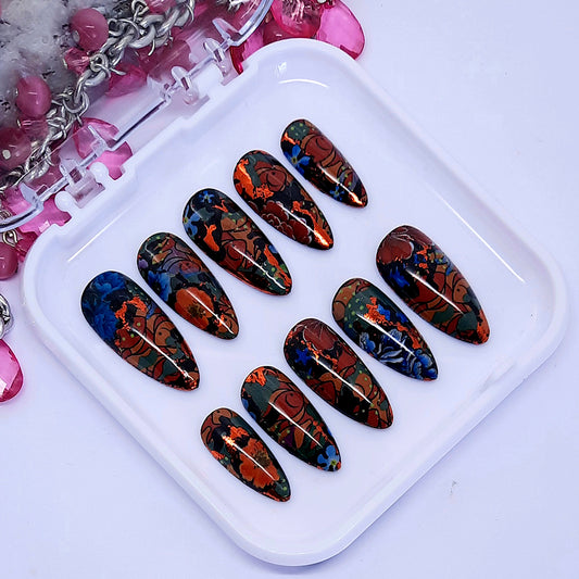 a stunning set of black almond press on nails with and abstract design of fish and flowers