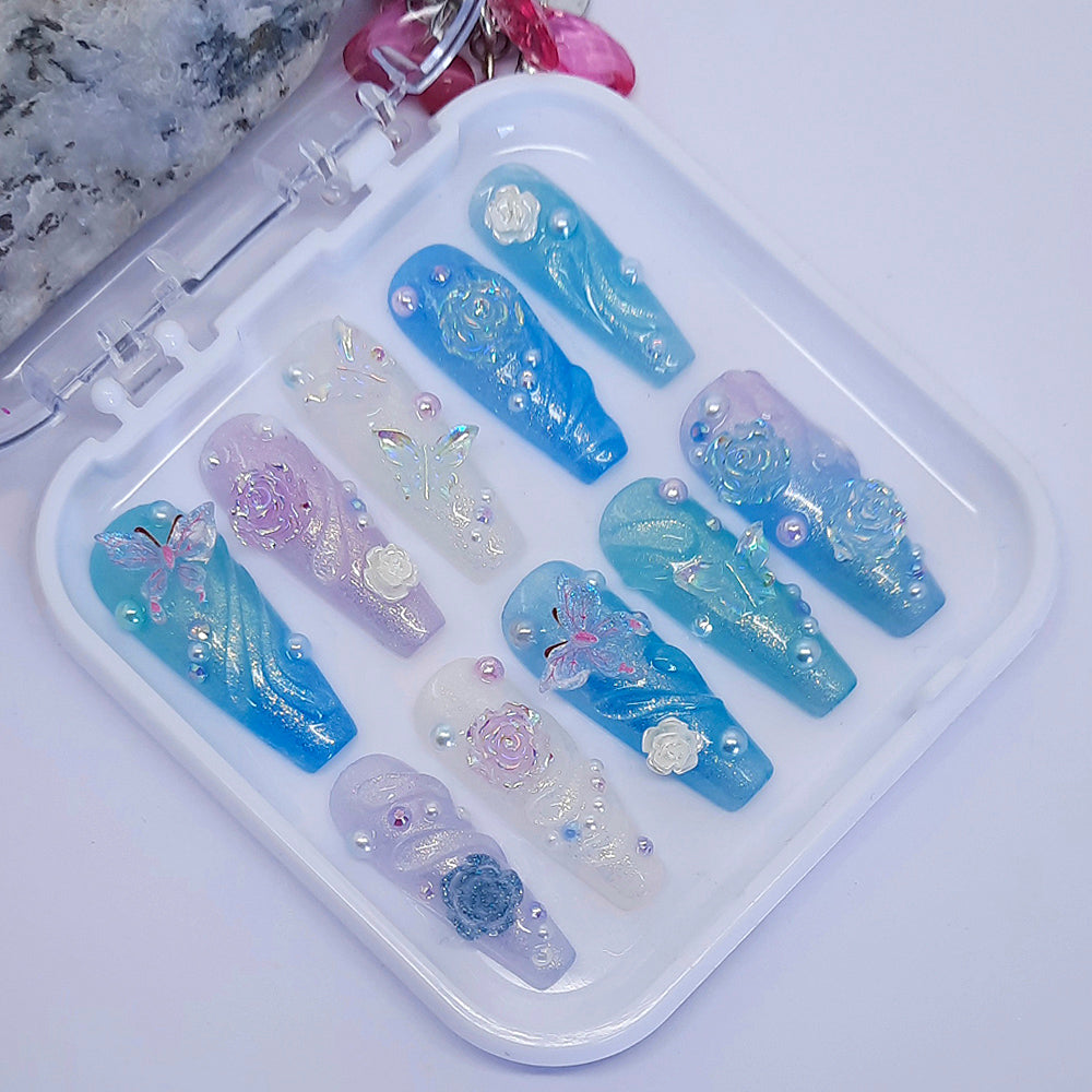 beautiful press on nails in soft shimmering colours, with 3d butterflies, flowers, swirls, gems and pearls