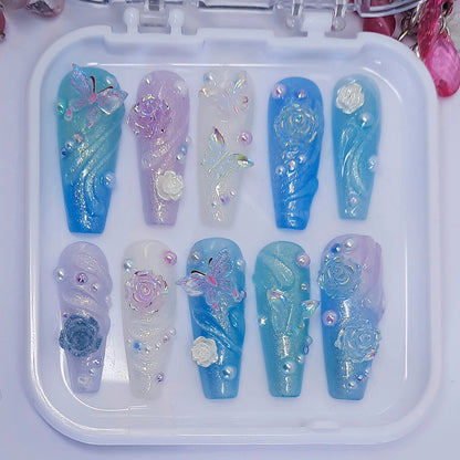 beautiful press on nails in soft shimmering colours, with 3d butterflies, flowers, swirls, gems and pearls