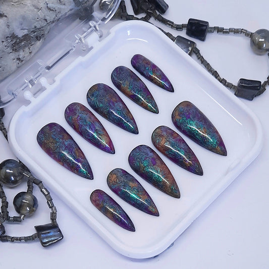 A beautiful set of press on nails in dark pearly colours that have been swirled together giving oil spill vibes.