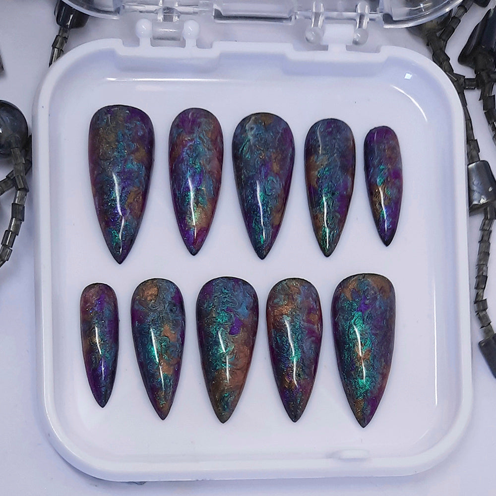 A beautiful set of press on nails in dark pearly colours that have been swirled together giving oil spill vibes.