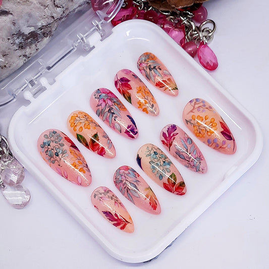 Set of colourful leaves nail art designs displayed on a white tray.