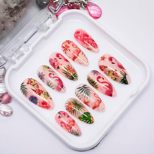Set of floral and flamingo-themed nail art designs on a white tray.