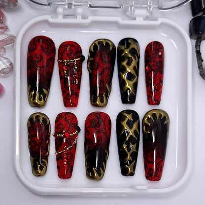 A beautiful red and black set of press on nails with black lace, gold chrome, gold caviar beads, red gems and black studs.