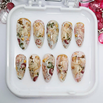Decorative nail art set with floral and angel designs on a white tray.