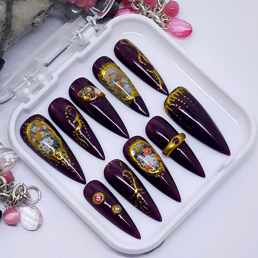 Beautiful sparkly deep purple press on nails with flowers, gold chrome and gems.