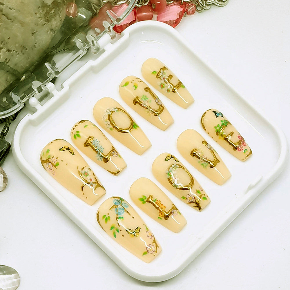 Beautiful press on nails in soft cream colour, with LOVE written in raised gold chrome and decorated with little flowers and butterflies. Finished in gloss top coat. These are so pretty.