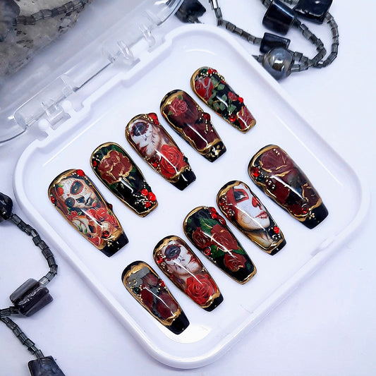 A set of black press on nails with a Day of The Dead design including red roses, 3d nail art and gold chrome. Finished in gloss top coat.