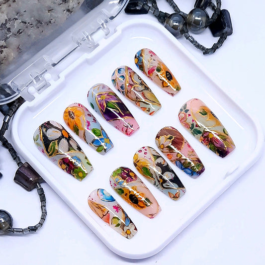 A set of hand made press on nails with a colourful abstract design of flowers with some gold chrome detail.