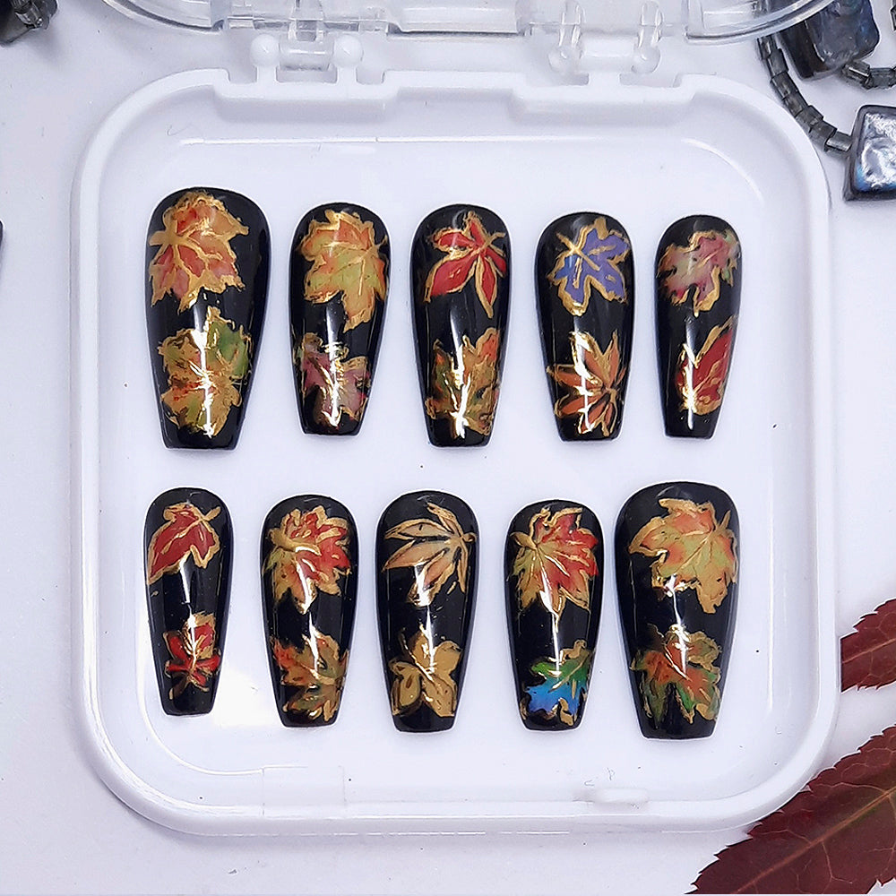 Set of nail art designs with autumn leaf patterns on black background