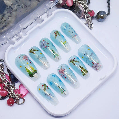 A set of press on nails in blue and white with a Christmas themed design, displayed in a white tray on a white background.