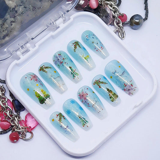 A set of press on nails in blue and white with a Christmas themed design, displayed in a white tray on a white background.