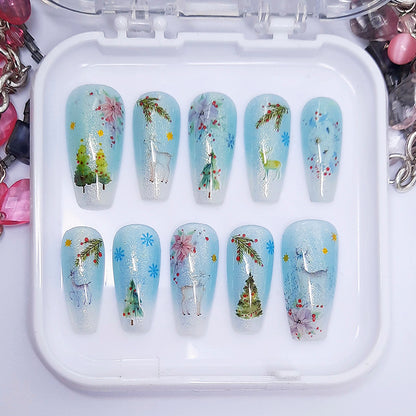 A set of press on nails in blue and white with a Christmas themed design, displayed in a white tray on a white background.