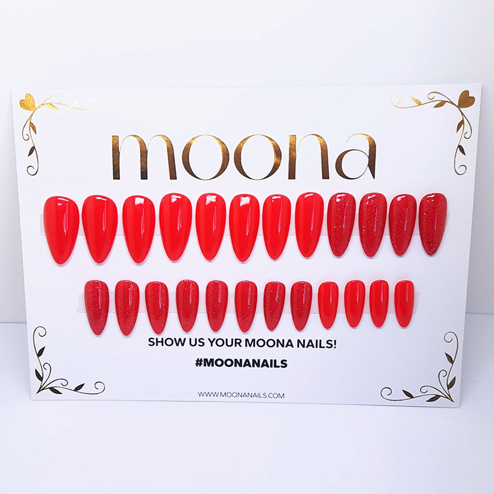 Red nail extensions on a Moona branded display card with a white background