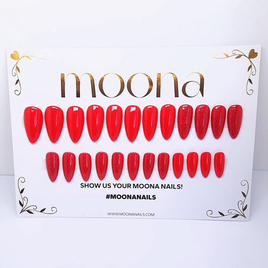 Red nail extensions on a Moona branded display card with a white background