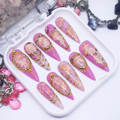 Set of decorative nail art designs on a tray with jewelry in the background