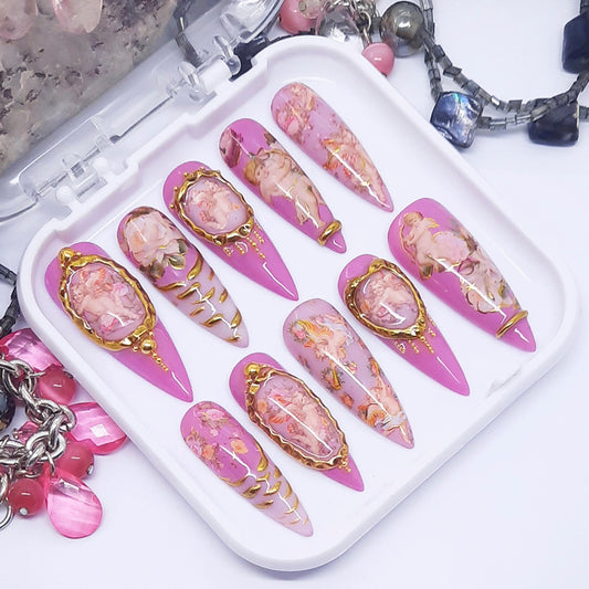 Set of decorative nail art designs on a tray with jewelry in the background