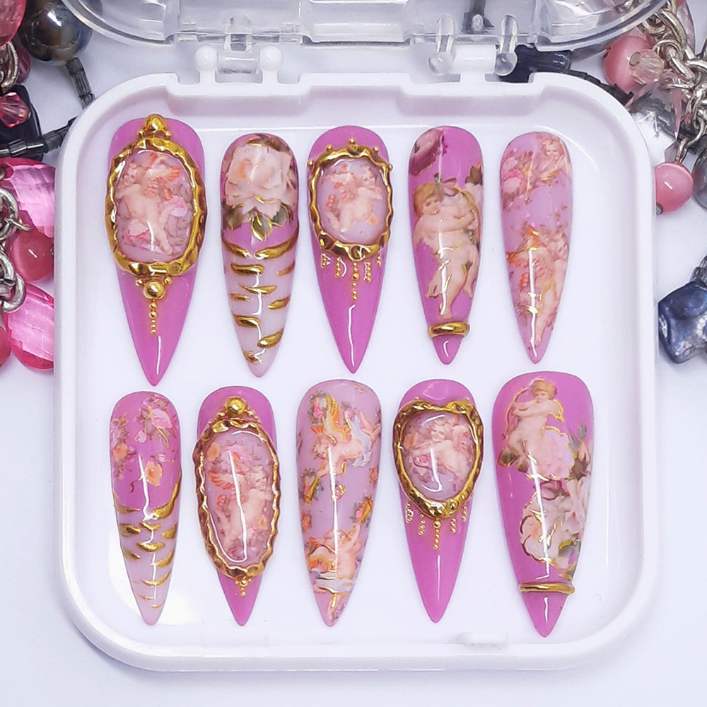 Decorative false nails with pink and gold designs in a white case.
