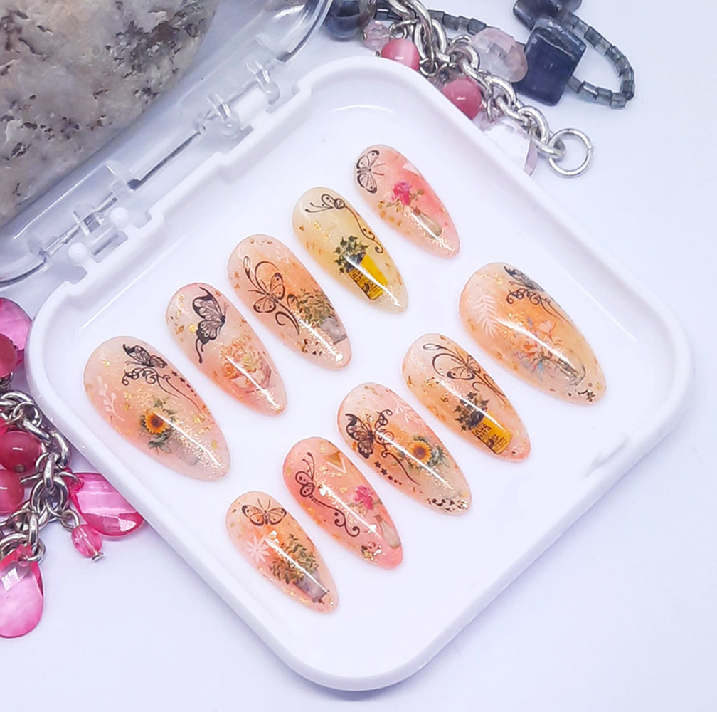 Decorative false nails with floral and butterfly designs on a white tray.