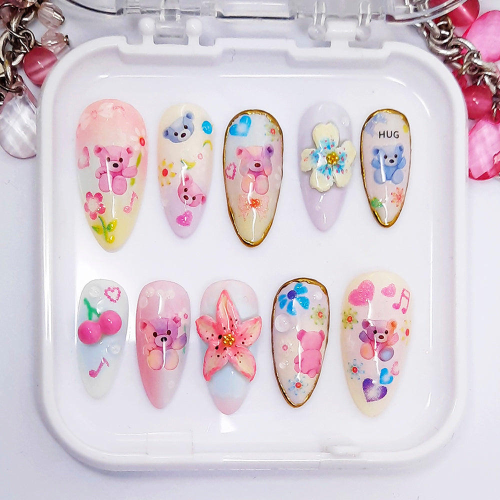 Set of decorative nail art designs in a white case with colourful patterns including bears, flowers, and stars.