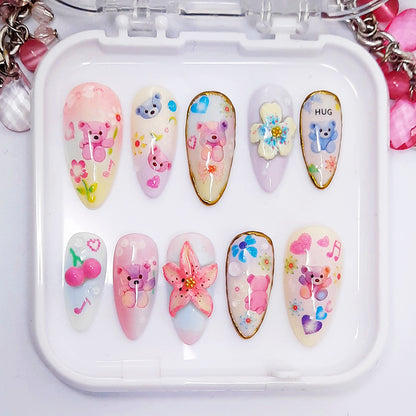 Set of decorative nail art designs in a white case with colourful patterns including bears, flowers, and stars.