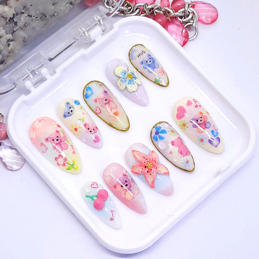 Set of decorative nail art designs in a white case with colourful patterns including bears, flowers, and stars.