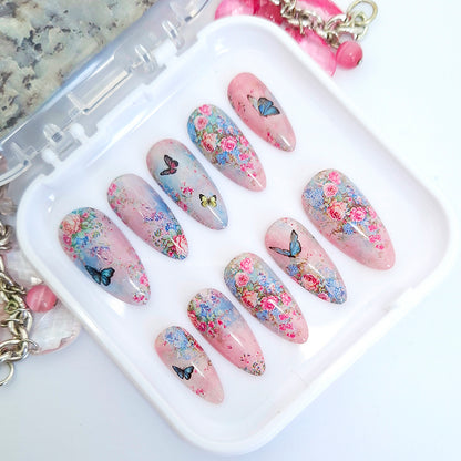 Decorative nail art with floral and butterfly designs on a white tray.