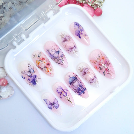 Decorative nail art designs with floral and butterfly designs on a white tray.
