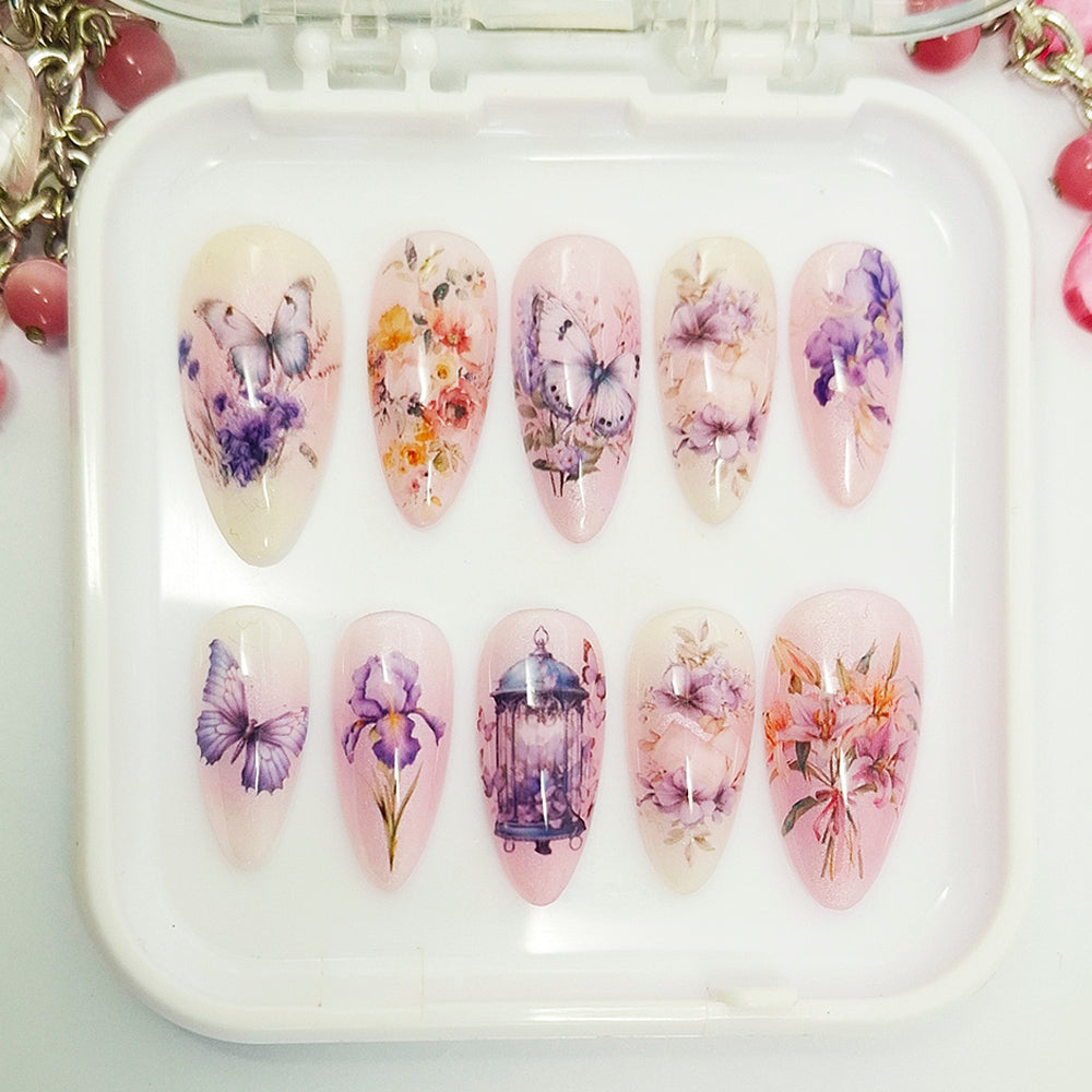 Set of floral and butterfly-themed nail art designs on a white tray.