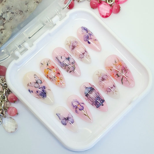 Set of floral and butterfly design press-on nails in a white case.