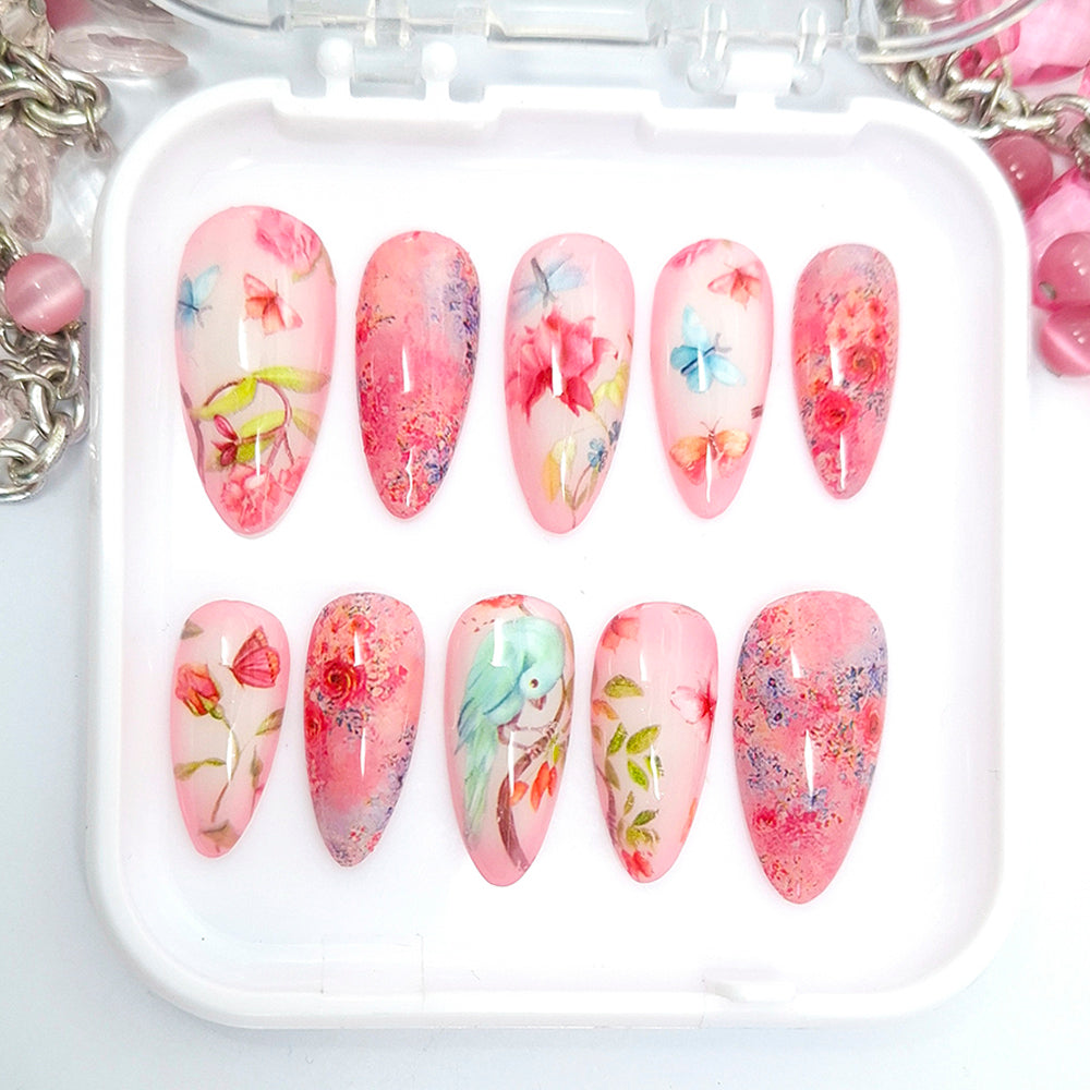 Set of floral nail art designs in a white tray with pink and multicolor patterns.