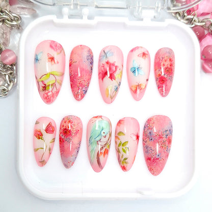 Set of floral nail art designs in a white tray with pink and multicolor patterns.
