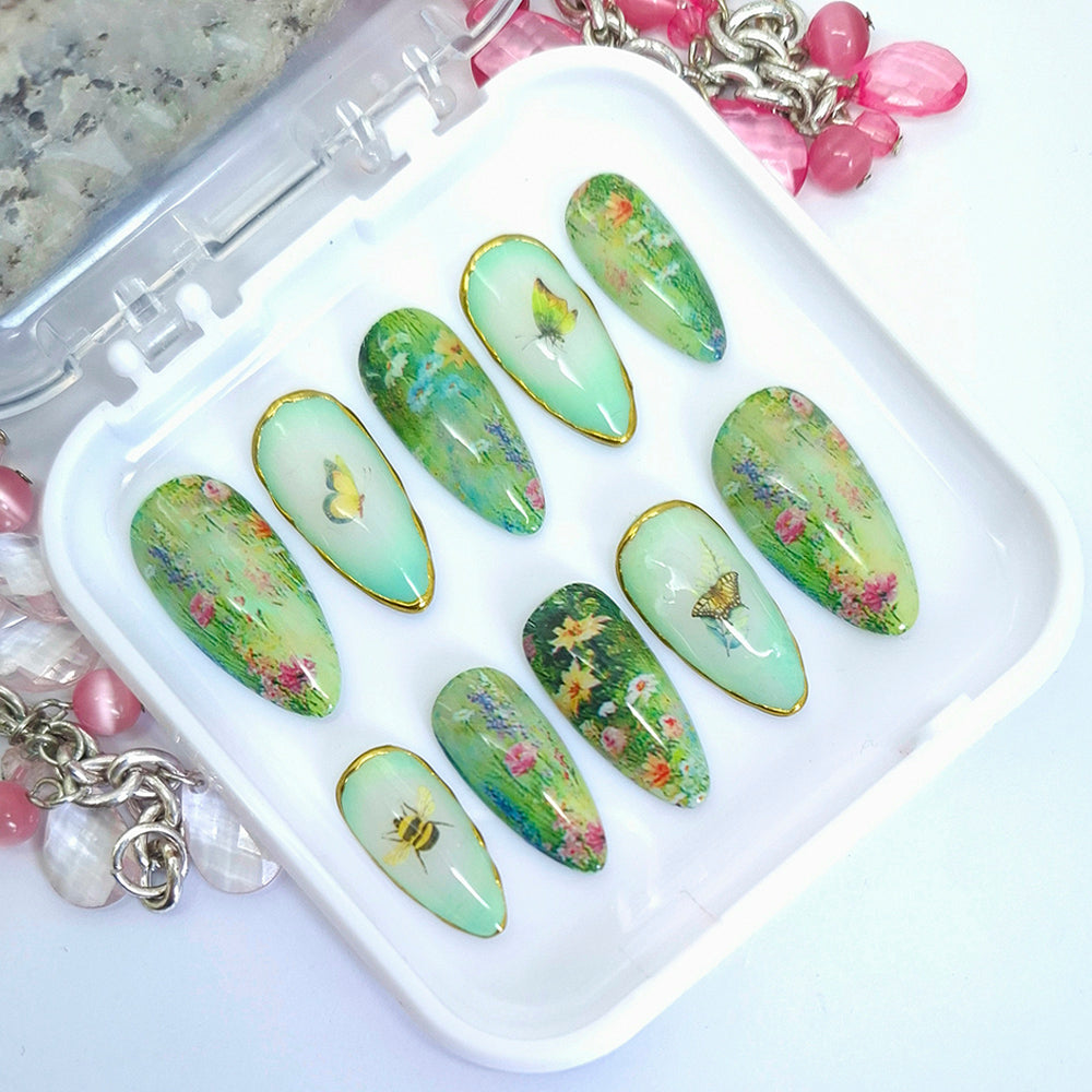 Set of green floral nail art designs on a white tray with decorative elements.