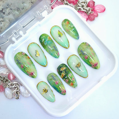 Set of green floral nail art designs on a white tray with decorative elements.