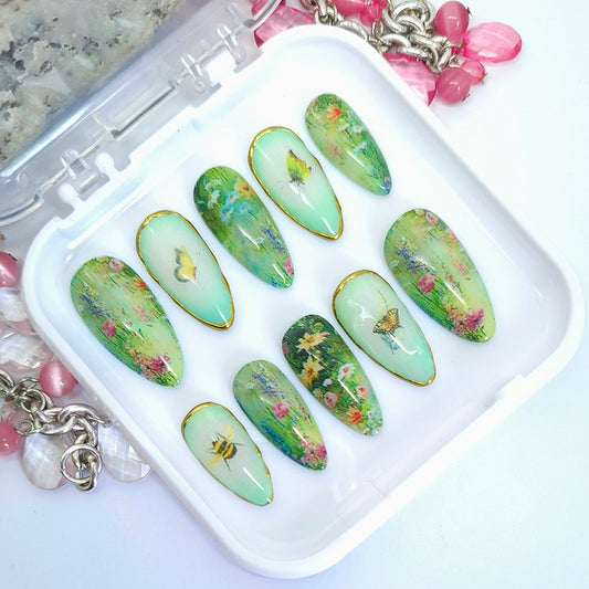 Set of green floral nail art designs on a white tray with decorative elements.