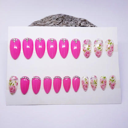 Set of pink and floral nail designs on a white card with a gray surface underneath.